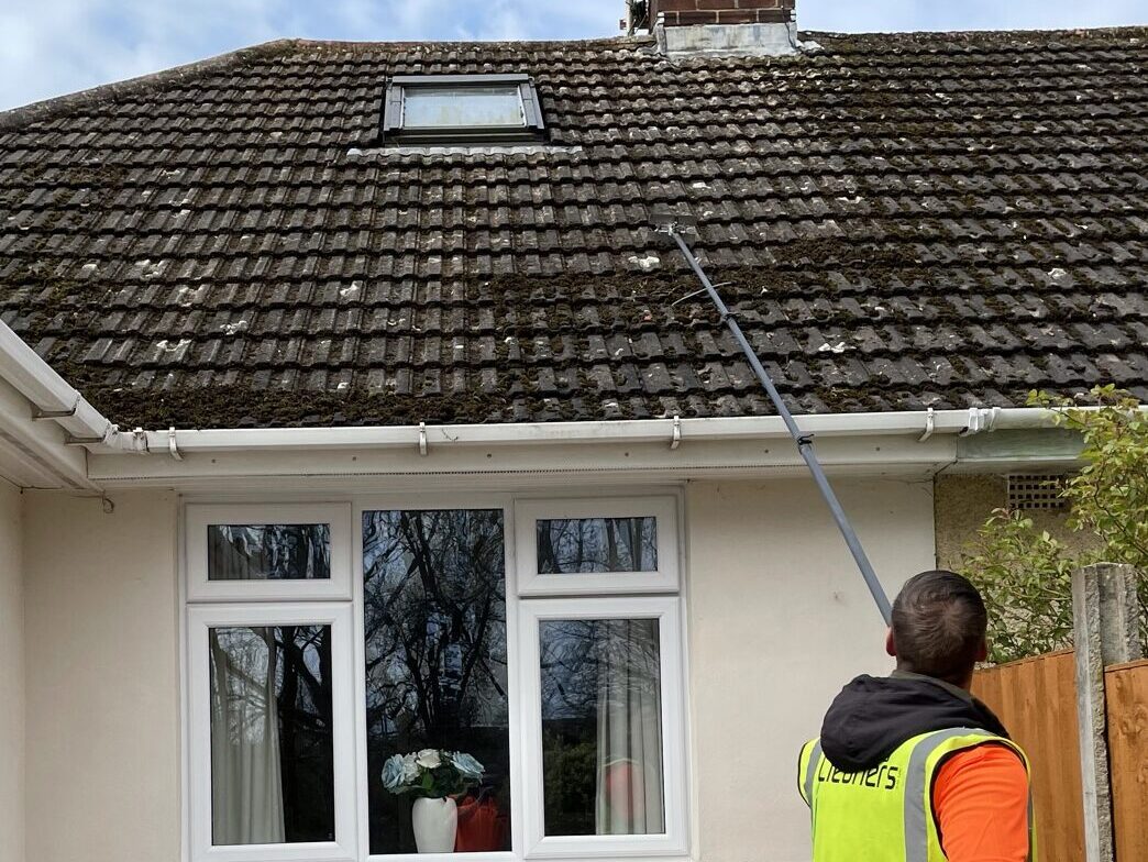 Softwash roof cleaning using scrapers to gently remove moss from the roof tiles.